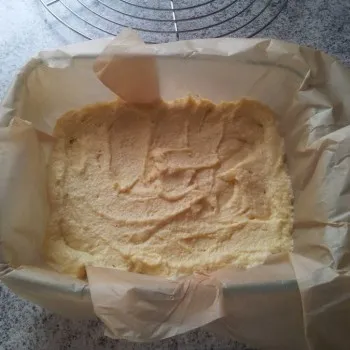 Die Auflaufform mit Backpapier auslegen und den Teig einfüllen.