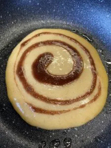 Auf mittlerer Hitze ganz sachte anbacken lassen, bis sich oben kleine Bläschen bilden.